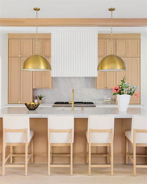 Kitchen featuring tasteful backsplash, light brown cabinetry, sink, and an island with sink