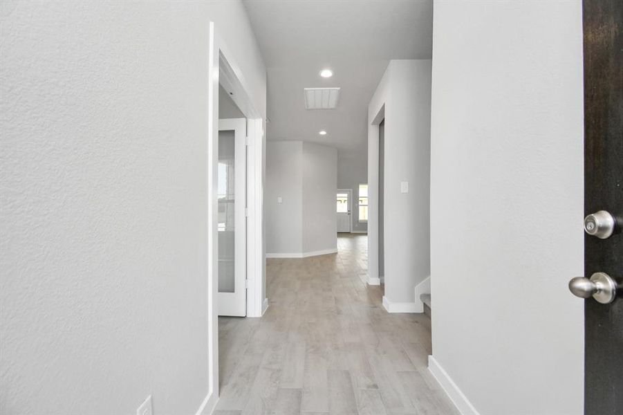 Step into elegance and sophistication in the entryway of this home, where wood-look tile flooring and high ceilings create a grand and welcoming atmosphere. Sample photo of completed home with similar plan. As built color and selections may vary.