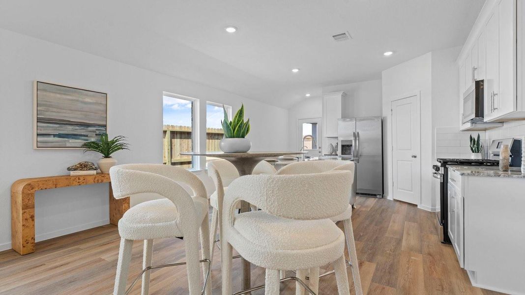 Spacious open concept dining area with vinyl wood flooring and access to the living and kitchen areas