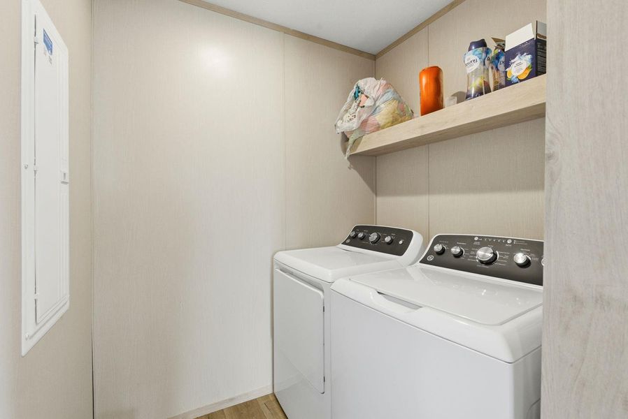 Laundry room with washing machine and dryer and light wood-type flooring