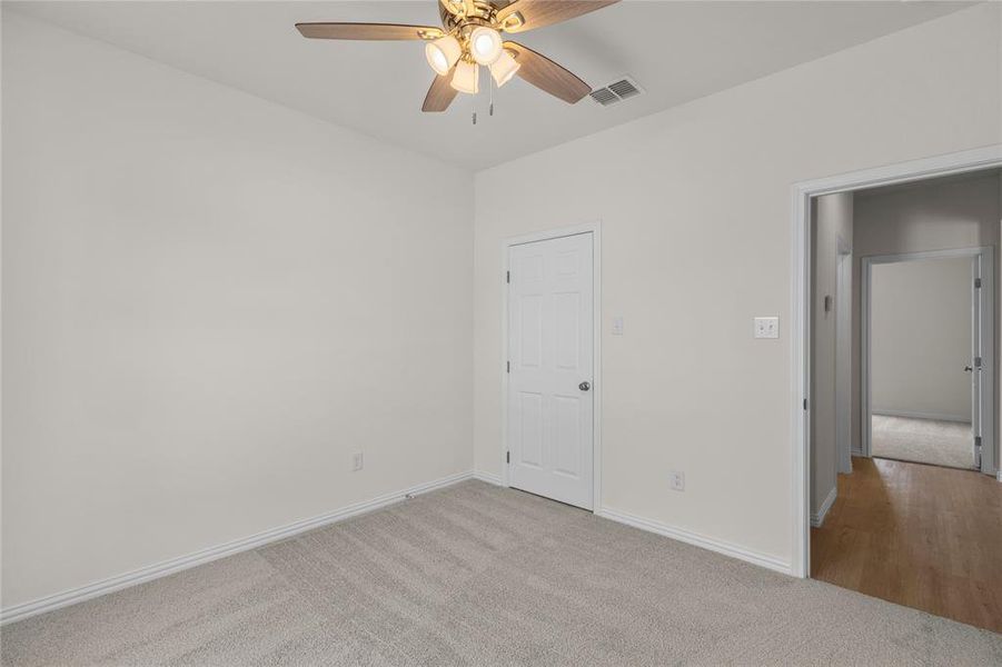 Unfurnished bedroom with light carpet and ceiling fan