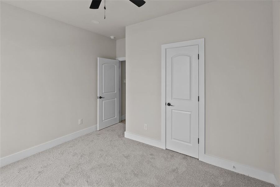 Unfurnished bedroom featuring carpet flooring, baseboards, and ceiling fan