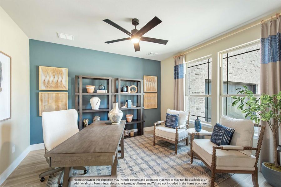 Home office with wood desk, teal accent wall, open shelving, ceiling fan, and two accent chairs near large windows Home office with wood desk, teal accent wall, open shelving, ceiling fan, and two accent chairs near large windows
