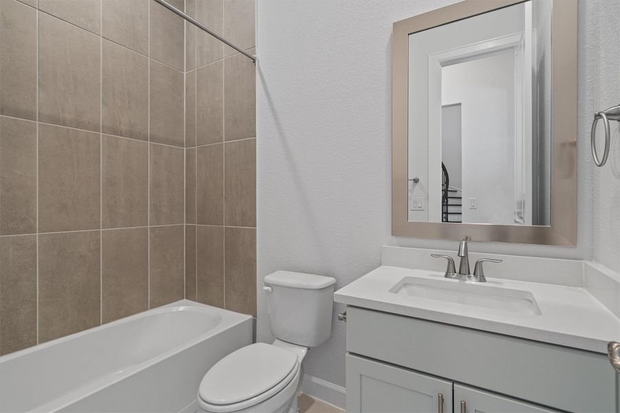 Bathroom featuring a textured wall, vanity, and bathing tub / shower combination Bathroom featuring a textured wall, vanity, and bathing tub / shower combination
