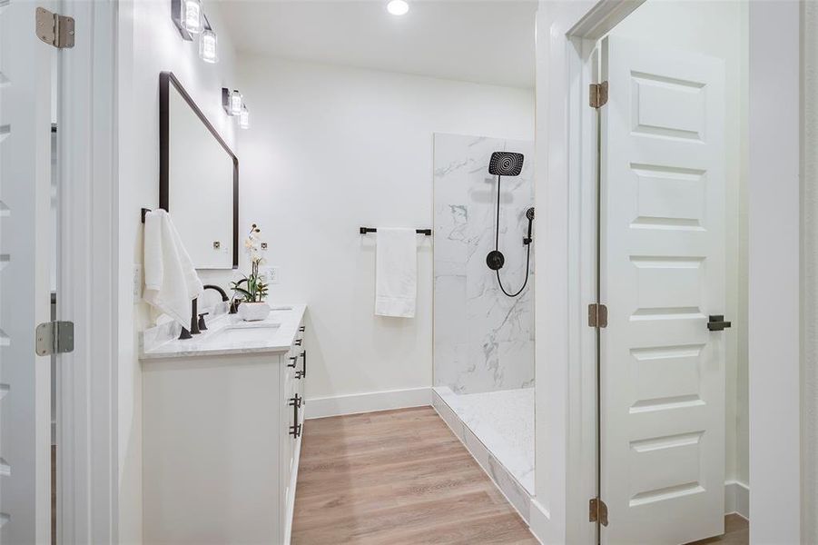 Bathroom with hardwood / wood-style flooring, vanity, and walk in shower