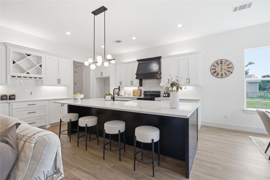 Culinary adventures await in this chef's kitchen, featuring a spacious island and bright cabinetry. Culinary adventures await in this chef's kitchen, featuring a spacious island and bright cabinetry.