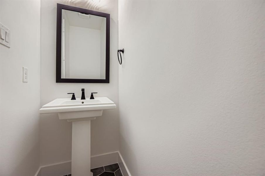 Bathroom featuring baseboards and dark tile patterned flooring