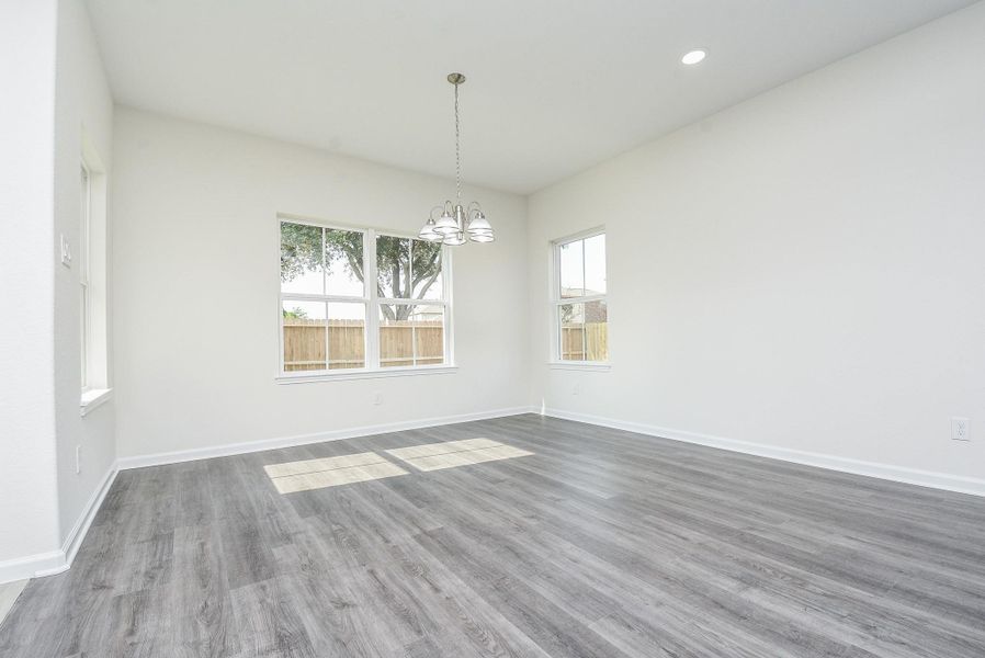 This is a bright, spacious room with large windows that allow for plenty of natural light, a modern chandelier, and stylish gray flooring. It's a blank canvas ready for personal touches. This is a bright, spacious room with large windows that allow for plenty of natural light, a modern chandelier, and stylish gray flooring. It's a blank canvas ready for personal touches.