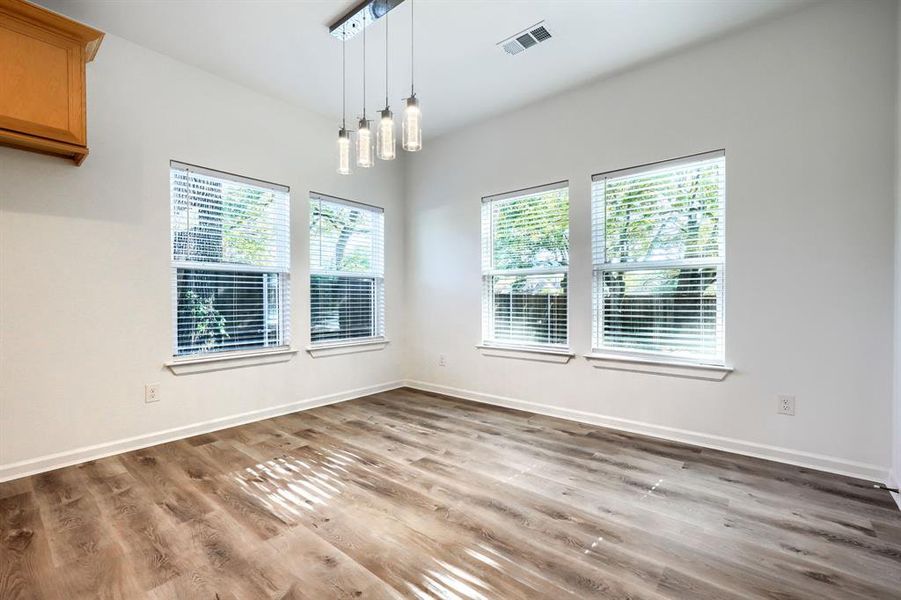 Unfurnished dining area featuring healthy amount of natural light and light wood-style floors