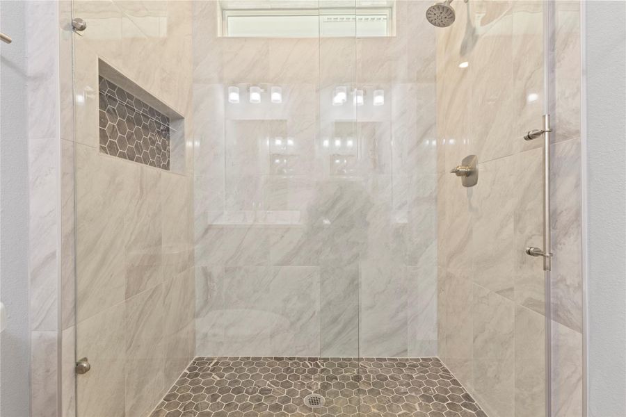 Wonderful and elegant primary shower, spacious, great design and with beautiful transom window.