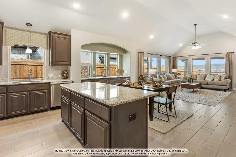 Open-concept kitchen with granite island and dark wood cabinets flowing into living room with vaulted ceiling