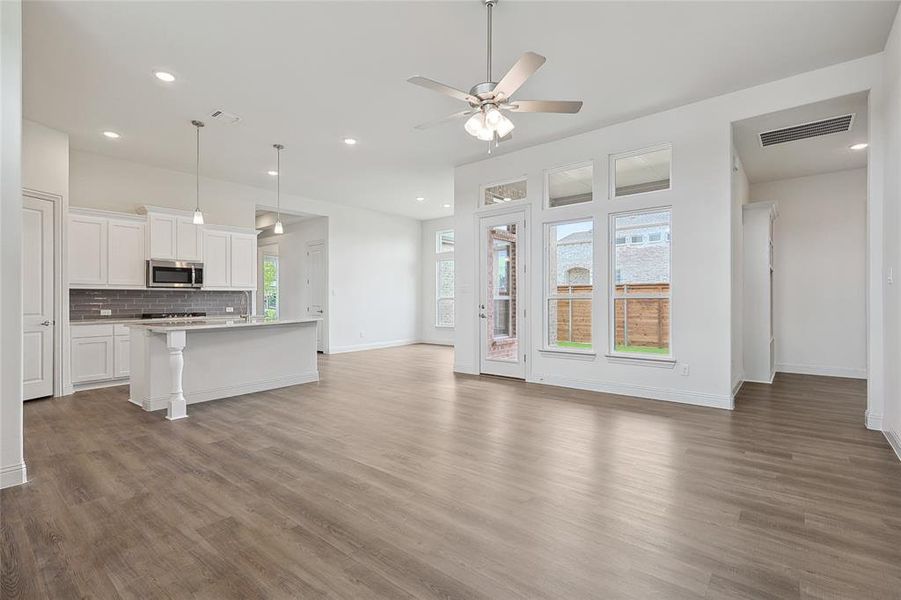 Kitchen with ceiling fan, decorative light fixtures, a healthy amount of sunlight, and white cabinetry