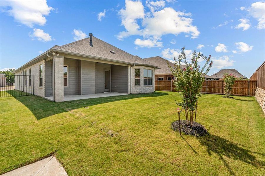 Back of property with a lawn and a patio