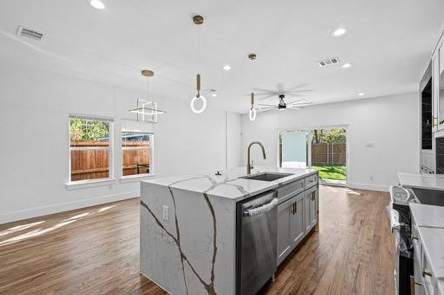 Kitchen with a center island with sink, stainless steel appliances, a healthy amount of sunlight, and sink