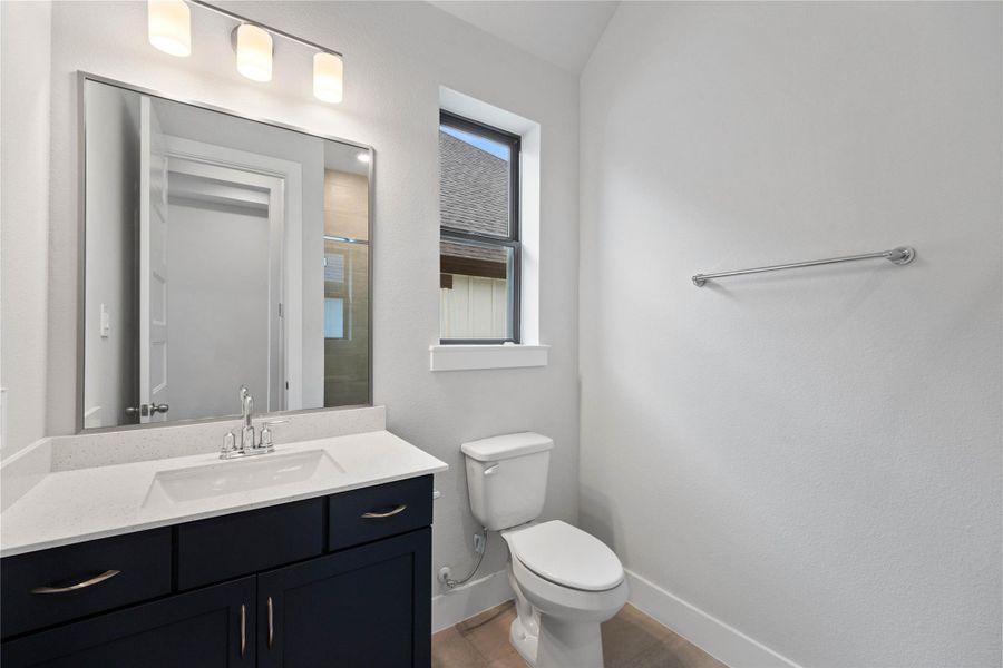 This well-appointed secondary bathroom offers exceptional functionality with its stained cabinet, light countertop and convenient undermount sink. The walk-in shower with tile surround and built in shelf are all finished with sleek, polished fixtures.