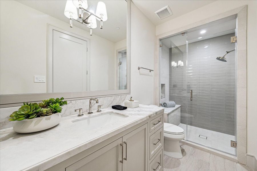 The first floor bathroom features Ecosystems Jute Vein porcelain tile with Aquarelle Griege horizontal tile accent wall, large format shower head, and frameless glass enclosure. The first floor bathroom features Ecosystems Jute Vein porcelain tile with Aquarelle Griege horizontal tile accent wall, large format shower head, and frameless glass enclosure.