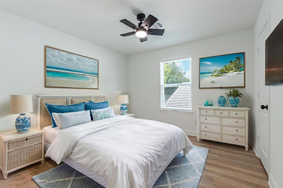 3rd spacious bedroom with vinyl flooring, ceiling fan, 2" blinds, and walk-in closet with built-in storage. Virtually staged.