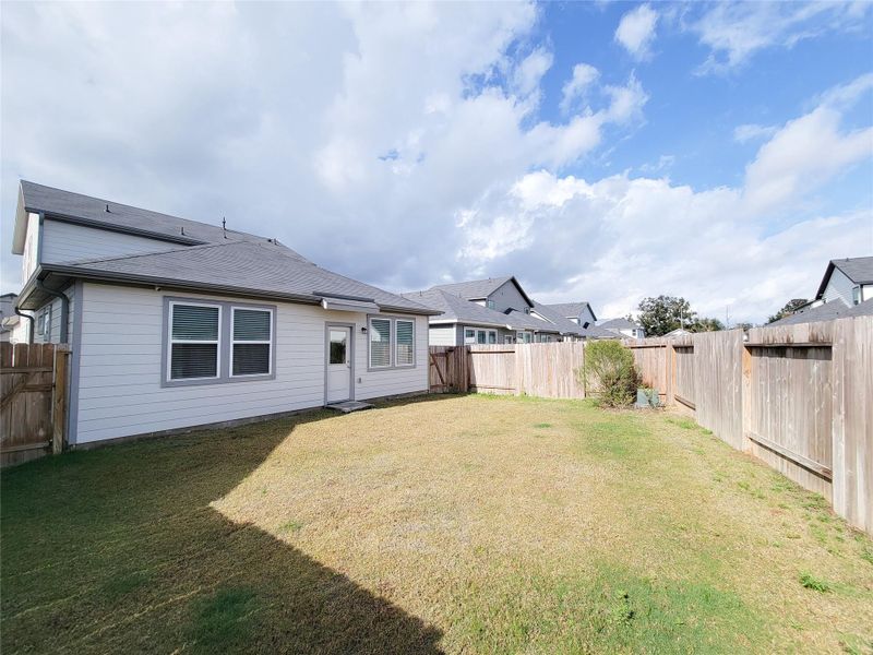 Fenced backyard. The space is open and well-maintained, suitable for outdoor activities or gardening.