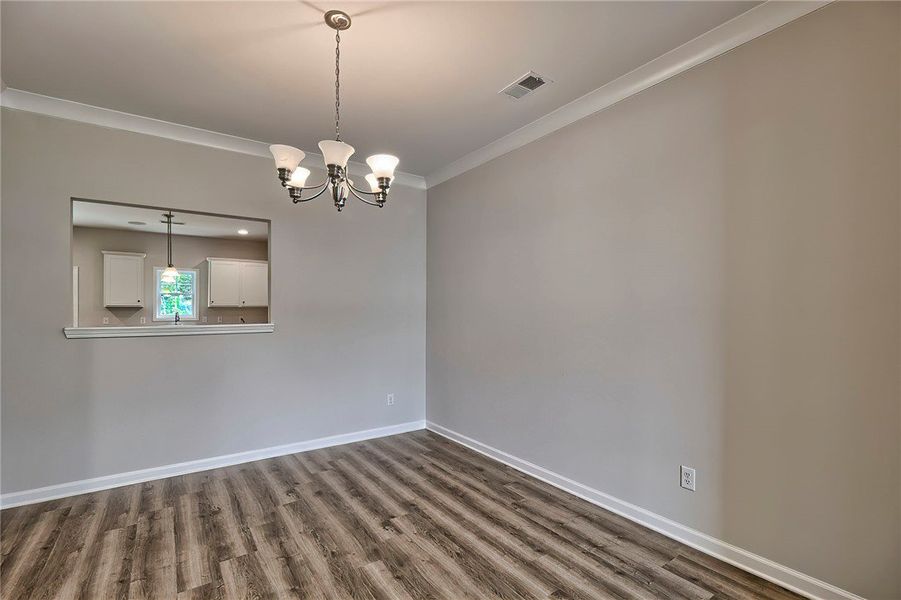 This spacious dining room features elegant crown m