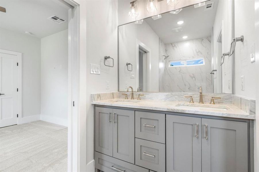 Bathroom featuring vanity and tiled shower