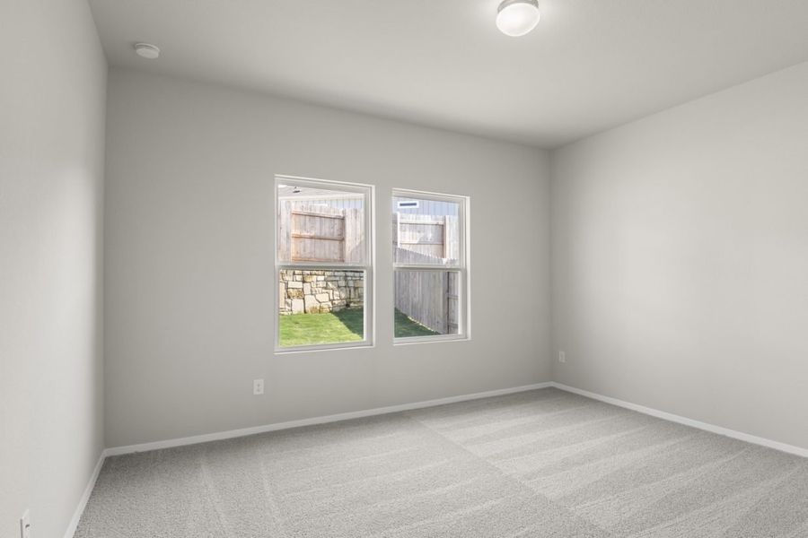 Image of primary bedroom with light grey carpet and light grey walls with two windows Image of primary bedroom with light grey carpet and light grey walls with two windows