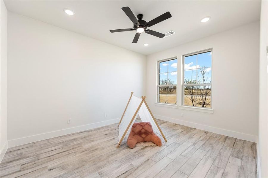 Recreation room with light wood finished floors, ceiling fan, and recessed lighting