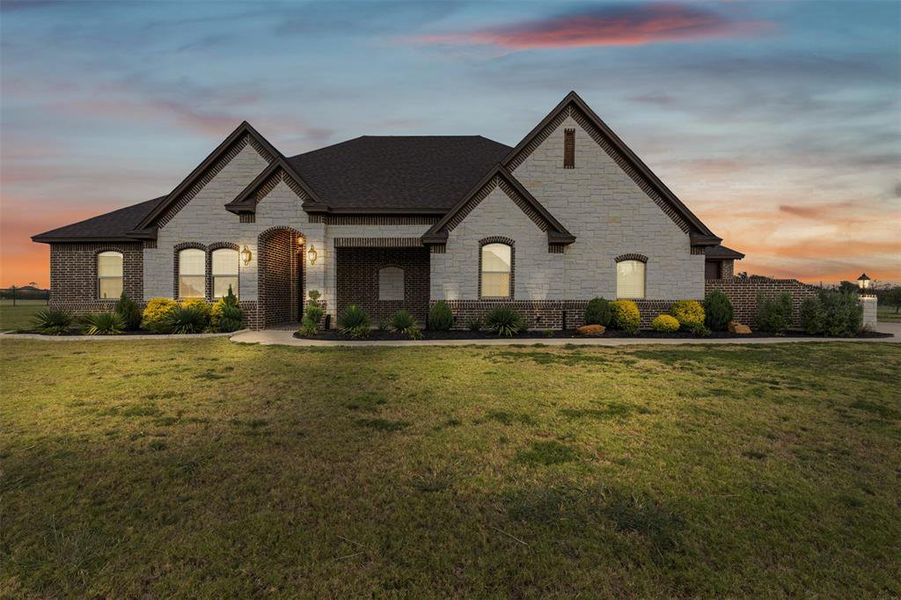 French country inspired facade with stone siding, brick siding, and a shingled roof French country inspired facade with stone siding, brick siding, and a shingled roof