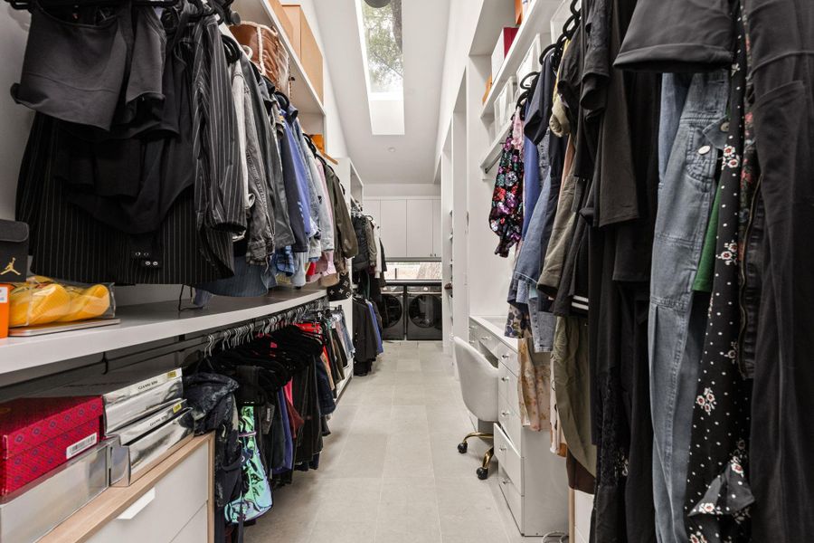 A well-organized walk-in closet offers extensive storage solutions and an integrated laundry area. A well-organized walk-in closet offers extensive storage solutions and an integrated laundry area.