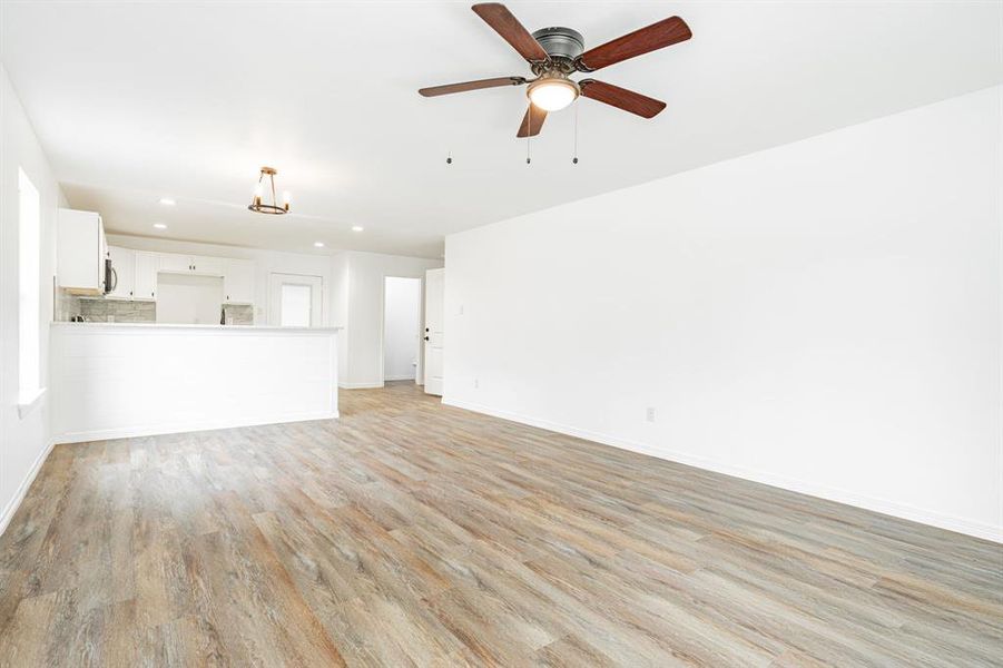 Unfurnished living room featuring light hardwood / wood-style floors and ceiling fan