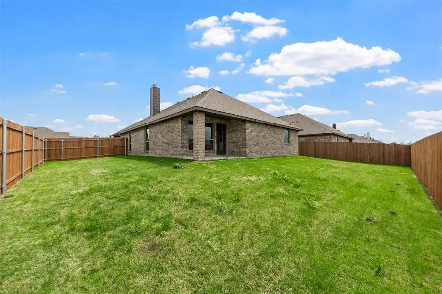 Expansive grassy backyard featuring a full privacy fence