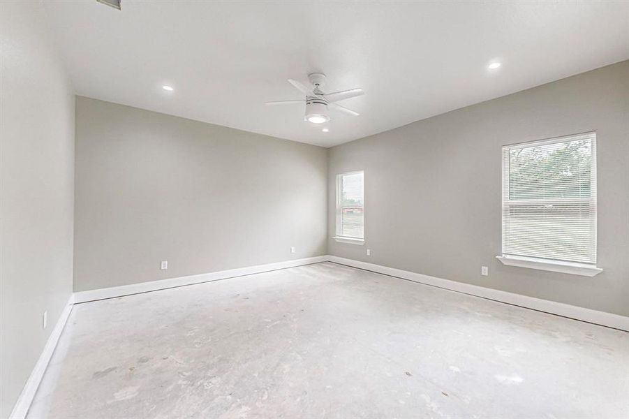 Unfurnished room with ceiling fan and concrete flooring