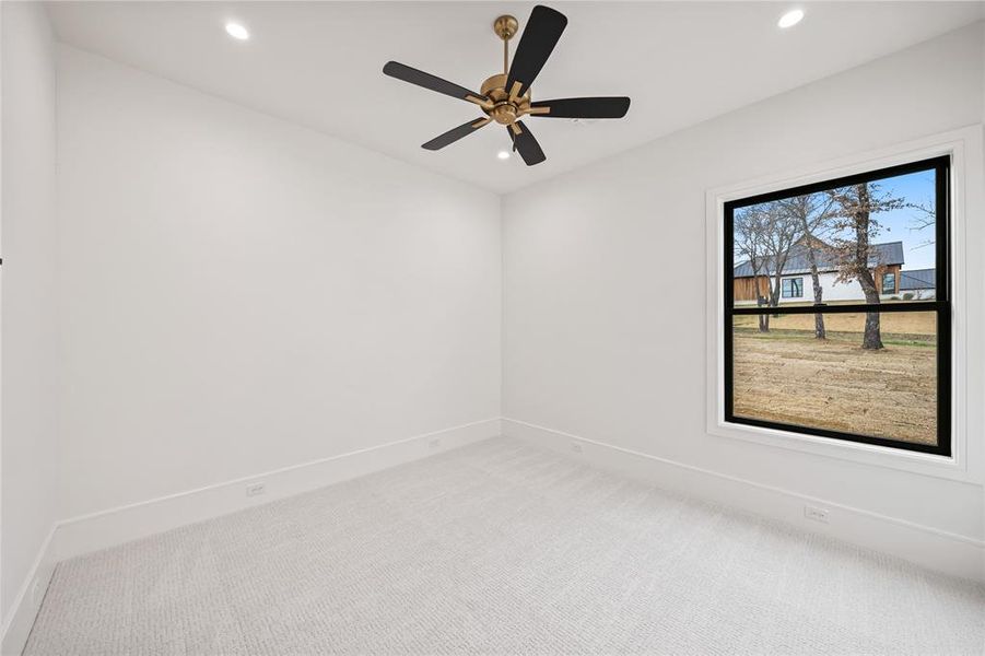 Room featuring light-colored carpet, white walls, and a window with black trim