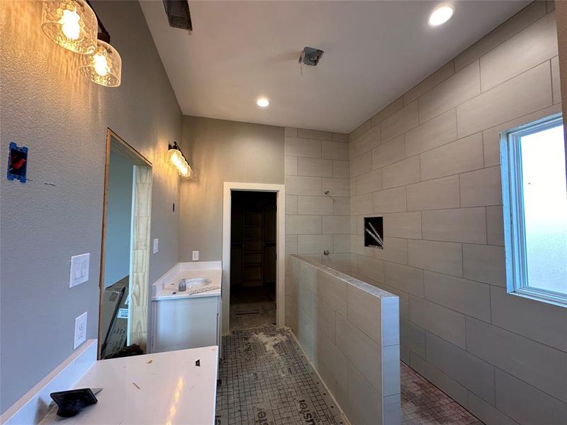 Bathroom with tile patterned floors, vanity, walk in shower, and tile walls