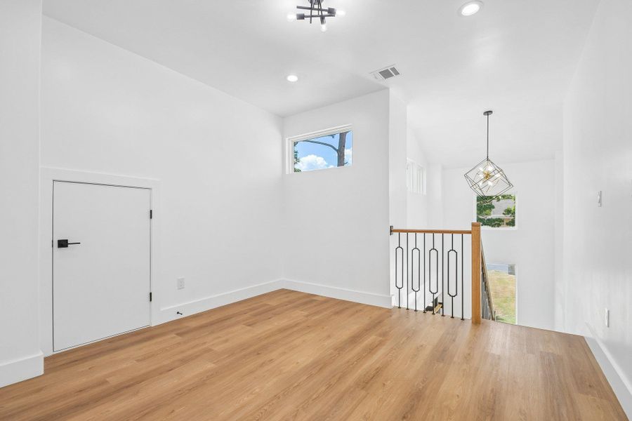 Natural light streams through high windows onto a versatile loft space with warm wood floors. Natural light streams through high windows onto a versatile loft space with warm wood floors.