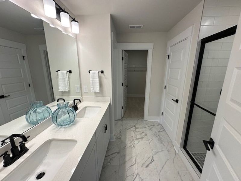 This primary bathroom features a dual vanity, slee