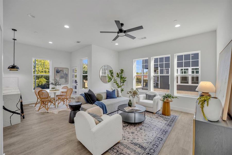 Living room with ceiling fan and light hardwood / wood-style flooring