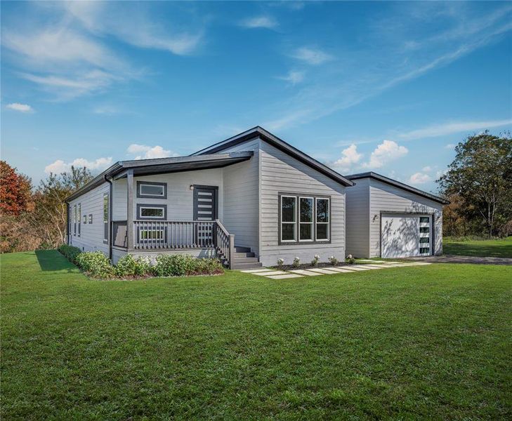 View of front of home featuring a front lawn, an attached garage, and driveway