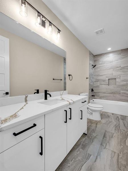 Full bathroom featuring vanity, toilet, and tiled shower / bath