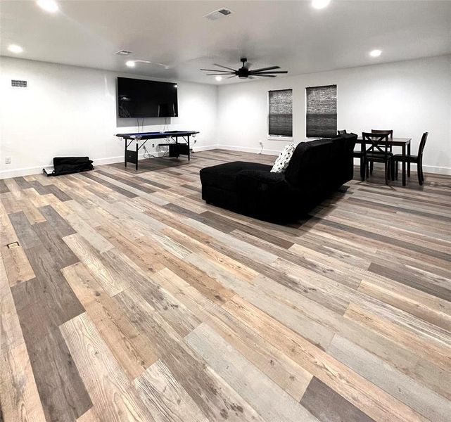 Living room with ceiling fan and light hardwood / wood-style flooring