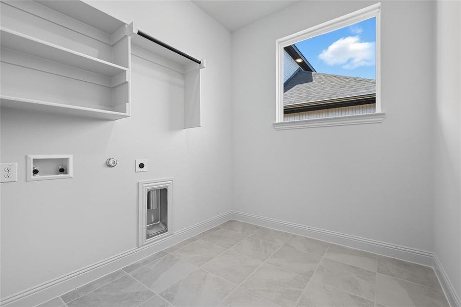 Washroom featuring gas dryer hookup, hookup for an electric dryer, hookup for a washing machine, and light tile patterned floors