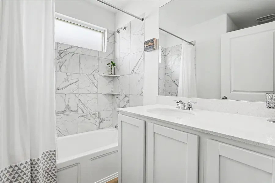 Bathroom featuring a white vanity with an integrated sink and light-colored countertop