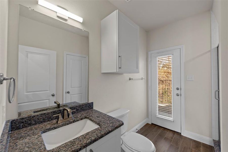 Bathroom featuring wood tiled floors, vanity, and a shower stall