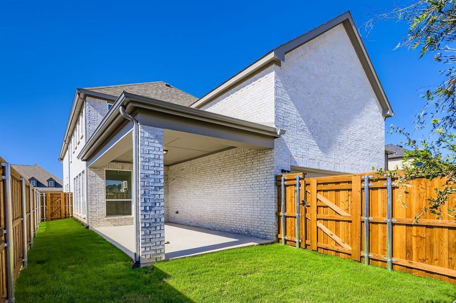 Rear view of house featuring a gate, a fenced backyard, a patio, roof with shingles, and brick siding Rear view of house featuring a gate, a fenced backyard, a patio, roof with shingles, and brick siding