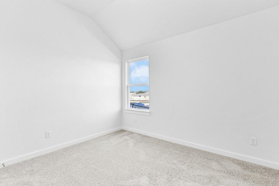 Carpeted empty room with vaulted ceiling and baseboards