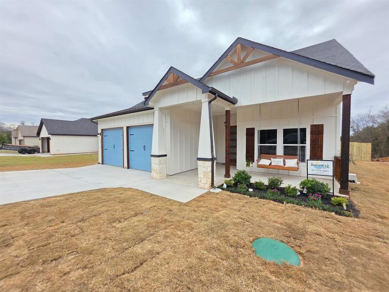 Picture of covered front porch included with home purchase wooden front porch swing.