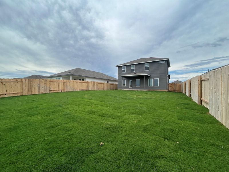 Rear view of property featuring a fenced backyard