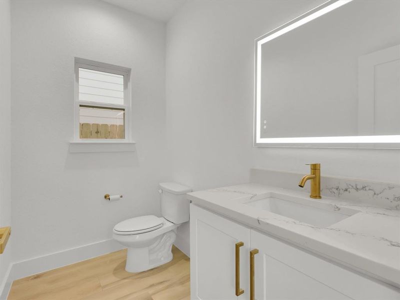 Bathroom with hardwood / wood-style floors, vanity, and toilet