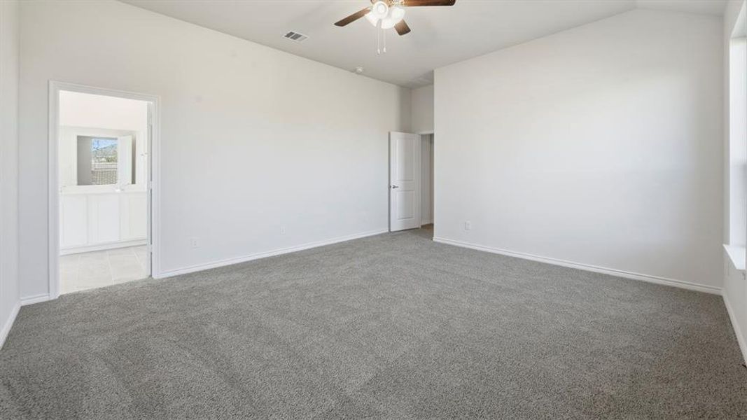 Unfurnished room with carpet flooring, vaulted ceiling, and ceiling fan