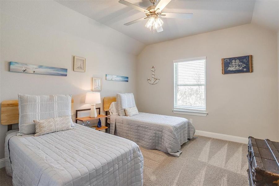 Carpeted bedroom with vaulted ceiling and ceiling fan