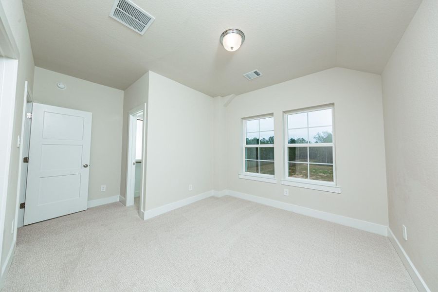 This inviting secondary bedroom boast of the two large windows, plush carpeting, a neutral color palette, and easy access to the secondary bathroom.